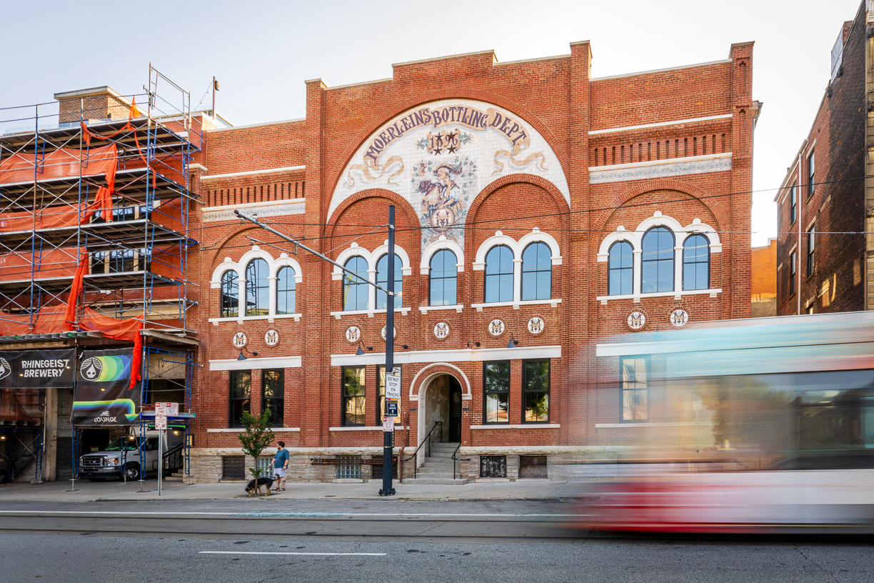 Rhinegeist Brewery Low Res THP provided façade assessment, repair design, and construction administration services for the restoration of Rhinegeist Brewery's historic masonry façade in Cincinnati's Over-the-Rhine neighborhood. The project originated after deteriorated compromised concrete elements created safety concerns along the building exterior. An investigation revealed extensive deterioration of historic precast concrete components embedded within a multi-wythe masonry wall that supports portions of the building structure. THP developed a repair program that balanced public safety, historic preservation requirements, and ongoing brewery operations. The work included replacement of deteriorated precast concrete bands, parapet reconstruction, masonry repointing using historically appropriate mortar, and coordination with contractors to perform repairs while maintaining building access and minimizing disruption to adjacent streets and the neighboring streetcar line. The design team utilized laser scanning and Building Information Modeling (BIM) to document existing conditions and develop replacement components that matched the historic façade profile.